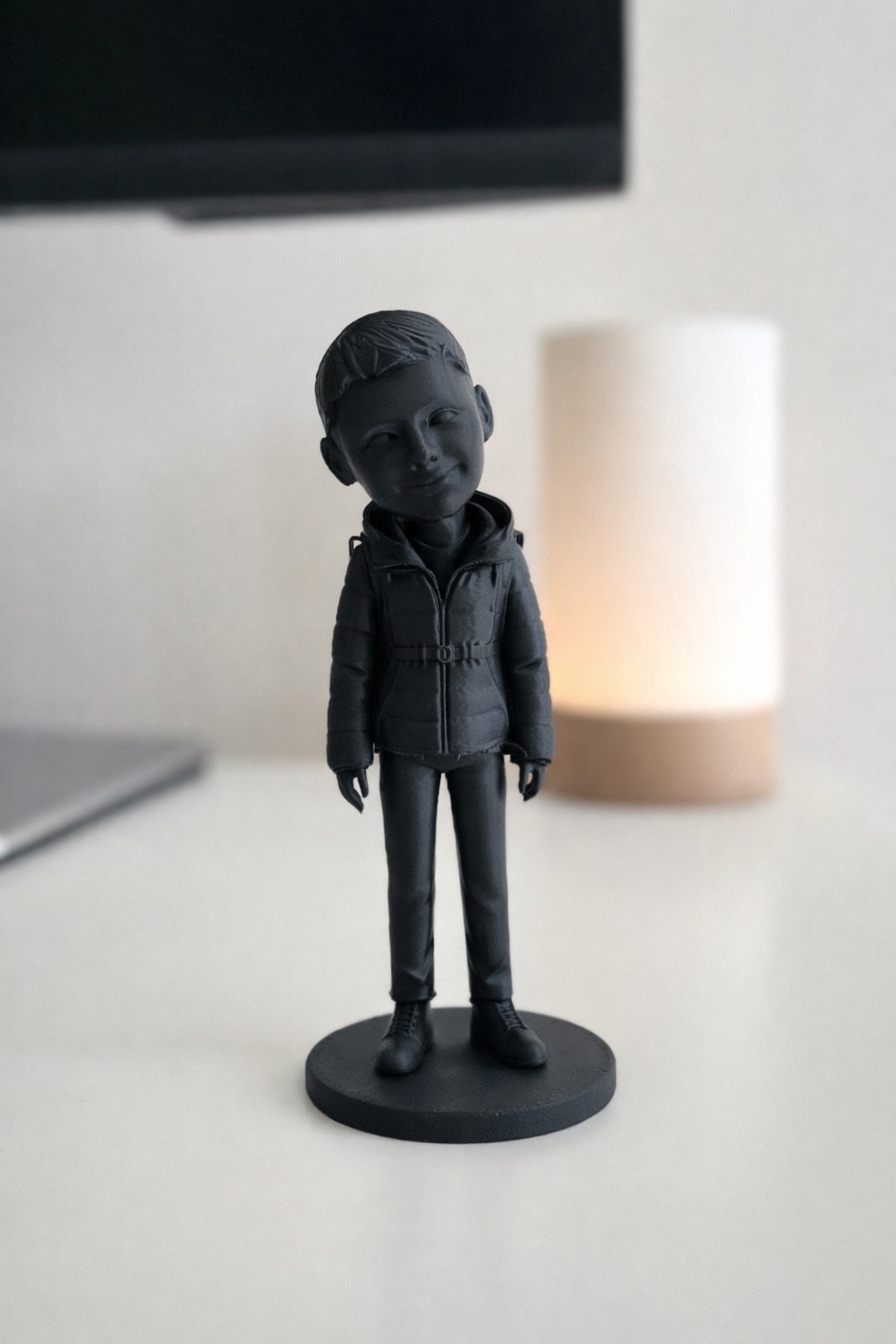 Графітова 3D-фігурка чоловіка в зимовій куртці-пуховику, на круглій підставці