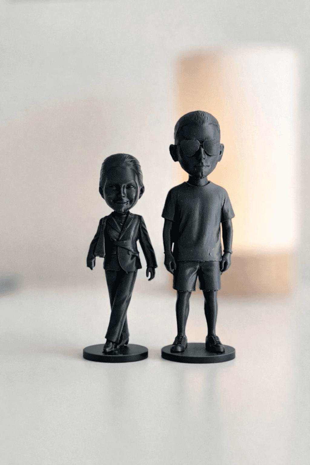 Dwie figurki 3D - para przy drukarce 3D z kolorowymi filamentami w tle